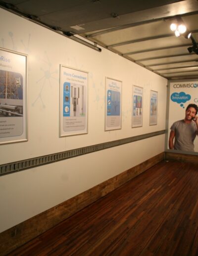 Empty truck interior with wooden flooring, featuring wall posters and two large printed figures.